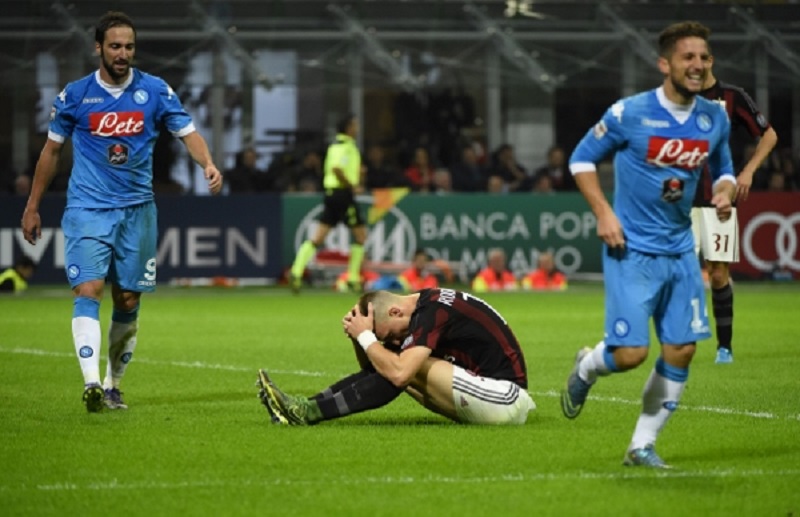 AC Milan's defender from Brazil Rodrigo Ely (C) reacts after scoring in his own goal as Napoli's forward from Argentina Gonzalo Higuain (L) walks past him during the Italian Serie A football match between AC Milan and Napoli at San Siro Stadium in Milan o